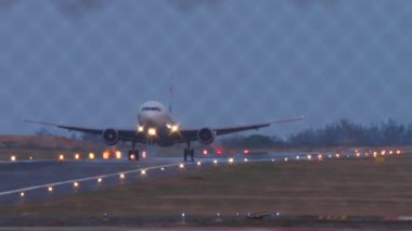 Jet uçağı iniyor, dokunuyor ve fren yapıyor. Uçak geliyor. Çitin arkasından bak. Pist aydınlatması. Spoiler verin. Turizm ve seyahat kavramı