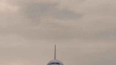 Modern jet tepemizde uçuyor. Çerçevenin ortasında. Uçak inmeye hazırlanıyor. Uçak iniyor. Görüntü