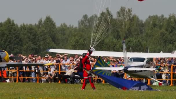ナオシビルスク ルシアンフェデレーション 2019年7月28日 赤いユニフォームのパラチューティスト スカイダイバーが着陸した 最高のスポーツ モシュタイン空気ドロームUnnmでのエアショー — ストック動画