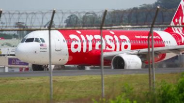 PHUKET, THAILAND - 27 Kasım 2015: AirAsia 'dan Lowcoster Airbus A320 Phuket havaalanında pistte taksicilik yapıyor. Taksideki uçaklar. Turizm seyahati kavramı