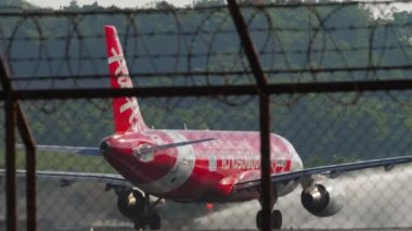 PHUKET, THAILAND - 10 Şubat 2023: Airbus A320, AirAsia 'dan HS-BBBW Phuket havaalanından kalkış. Havaalanı çitlerinden bak, uçak kalkış için hızlanıyor.