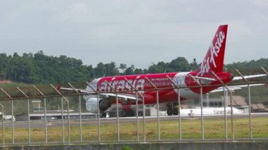 PHUKET, THAILAND - 27 Kasım 2015: AirAsia 'dan Lowcoster Airbus A320 Phuket havaalanında pistte taksicilik yapıyor. Taksideki uçaklar. Turizm seyahati kavramı