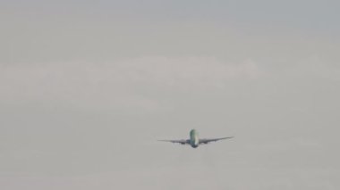 Yolcu uçağı mavi gökyüzünde ve beyaz bulutlarda çok uzaklara uçuyor. Havada uçak var. Uluslararası yolcu taşımacılığı. Uçak uzaktan uçuyor. Arkaplan