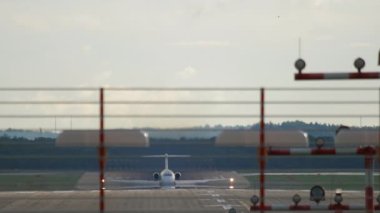 Hızlanan ve havalanan bir uçağın uzun mesafeli görüntüsü. Uçak kalkıyor..