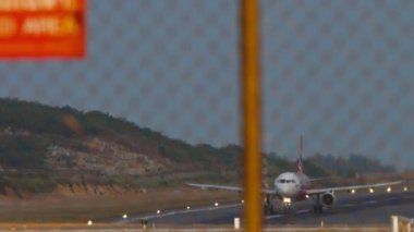 PHUKET, THAILAND - 23 HAZİRAN 2023: AirAsia 'nın Airbus A320 sefer sayılı yolcu uçağı. Uçak havalanıyor, tepemizde uçuyor.