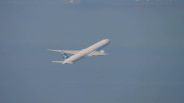 HONG KONG - 09, 2019 Cathay Pacific 'in geniş gövdeli hava aracı Boeing 777 kalkıştan sonra tırmanıyor. Yolcu uçağı kalkıyor. Uçak kalkıyor, yan görüş. Turizm seyahati kavramı