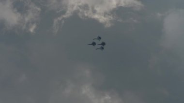 Askeri uçaklar akrobatik manevralar yapıyor. Uçak ordusu. Havada dönen uçak, aşırı uçuş.