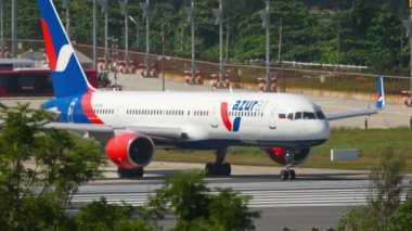 PHUKET, THAILAND - 26 Kasım 2016: Boeing 757, Azur Air 'in VP-BPB' si Phuket havaalanından kalkmadan önce piste iniyor. Havaalanında bir uçak gemisi var. Turizm seyahati kavramı