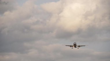 Uçak inişe geçiyor. Ticari uçak gri bulutlu gökyüzünde uçuyor, ön görüş, uzak ihtimal. Hava yolculuğu ve turizm konsepti