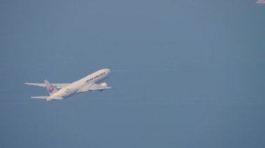 HONG KONG - Kasım 09, 2019: Japon Havayollarının ticari modern uçağı Boeing 777, Hong Kong havaalanında havalanıyor ve tırmanıyor. Yolcu uçağı kalkıyor