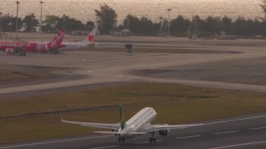 PHUKET, THAILAND - 19 Şubat 2023: Spring Airlines 'ın Airbus A320' si Phuket havaalanından havalanır. Uçak kalkıyor. Uçak tırmanışı. Güzel atış, uçak havalanıyor, güneş parlıyor.