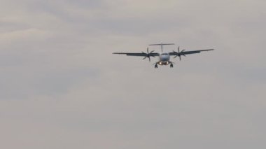 Tanımlanamayan bir üniforması olan turbopervaneli yolcu uçağı iniş yapıyor. Gökyüzünde bir uçak. Seyahat ve hava taşımacılığı kavramı