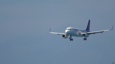 PHUKET, THAILAND - 26 Kasım 2016: Tayland Gülüşü uçağı Phuket havaalanına iniyor. Uçak denizin üzerinde uçuyor. Uçak geliyor. Turizm ve seyahat kavramı