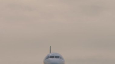 Uçak karaya çıkar, güneş batar. Alt görüş, yolcu uçağı iniyor, yaklaşıyor.