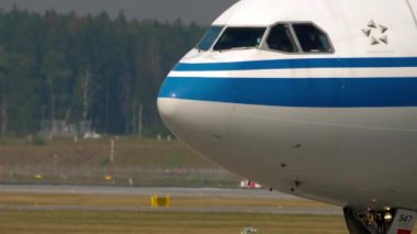 MOSCOW, Rusya Federasyonu - 29 Temmuz 2021 Airbus A330, B-5947 Air China Sheremetyevo havaalanında taksicilik yapıyor. Tıbbi maskeli pilot, pandemik dönem, koronavirüs.