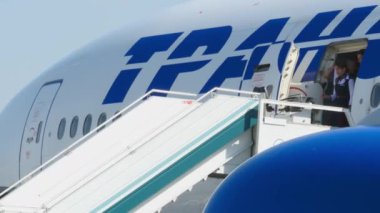 MOSCOW, Rusya Federasyonu - 26 Mayıs 2015: Transaero 'nun yolcu indirme uçağı Domodedovo havaalanında merdivenlerin kolunda. İnsanlar gündüz vakti uçaktan iniyor. İnsanlar, seyahat, tatil konsepti