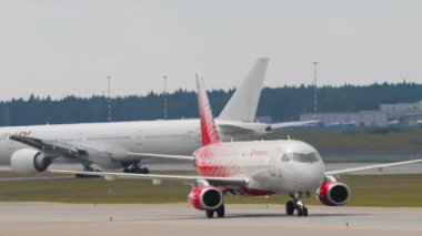 MOSCOW, Rusya Federasyonu - 29 Temmuz 2021: Rossiya uçağı Sheremetyevo havaalanında taksicilik yapıyor. Jet Rus Havayolları havaalanında. Arka planda Nordwind uçağı var. Büyük ve küçük uçak