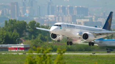 ALMATY, KAZAKHSTAN - 5 Mayıs 2019: Air Astana 'nın ticari uçağı Embraer E190 Almaty havaalanına varıyor. İnişten sonra uçuş freni, yan görünüm