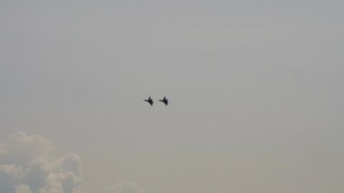Askeri uçaklar kalkıyor, uçuyor. İki savaş uçağının siluetleri. Gökyüzünde savaş uçağı var. Hava Kuvvetleri geçit töreni