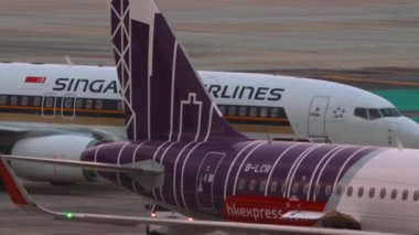 PHUKET, THAILAND - 27 Şubat 2023: Phuket havaalanında Boeing 737 Singapur Havayolları. Traktör bir yolcu uçağını çekiyor. Önlük, uçbirim