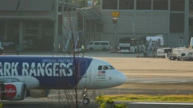 PHUKET, THAILAND - 26 Kasım 2016: Airbus A320, 9 M-AFV of AirAsia with Queens Park Rangers özel havaalanına varan Phuket havaalanı. İndikten sonra uçak fren yapıyor. Spoiler hazır.