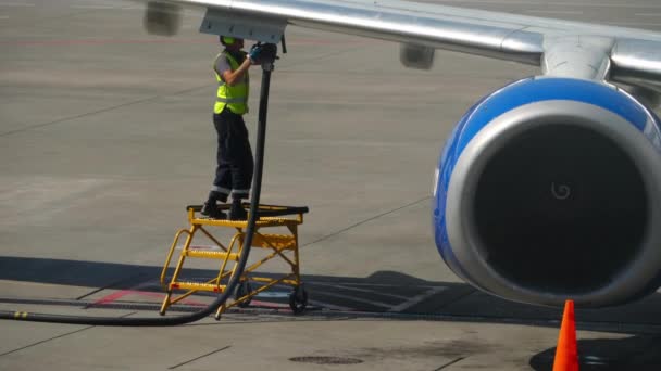 セントペーターズバーグ ロシア ジュール26 2022 空港の飛行機の乗組員が給油する航空機 出発のための飛行機の準備 航空機サービス労働者は 階段で飛行機の翼に燃料ホースを使用する — ストック動画