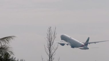 PHUKET, THAILAND - 31 Ocak 2023: Emirliklerin Boeing 777 'si Phuket havaalanında havalanıyor ve tırmanıyor. Uçuş kalkışı