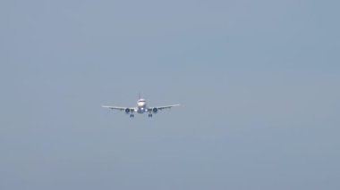 Tanımlanamayan bir üniforması olan yolcu uçağı iniş yapmak üzere, uzak ihtimal. Gökyüzünde bir jet uçağı, ön manzara.