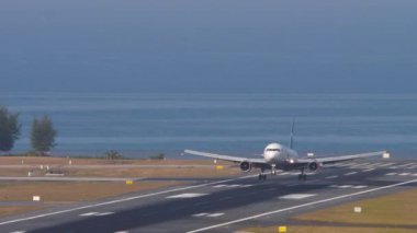 PHUKET, THAILAND - 23 Şubat 2023: Boeing 767-3Q8ER, RA-73030 Azur Air pistine iniş yaptı ve Phuket havaalanında fren yaptı. Yolcu uçağı geldi. Spoiler verin. Mavi deniz arka planı