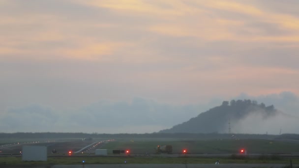 空の滑走路 朝早くから空港 ランディングライト 飛行場での作業車両 — ストック動画
