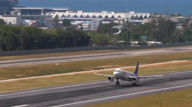 PHUKET, THAILAND - 23 Şubat 2023: Yolcu uçağı A320-232, Tayland gülüşlü HS-TXB, Phuket havaalanında havalanının panoramik görüntüsü.