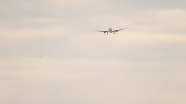 Jet uçağı gün batımında inişe geçiyor. Yolcu uçağı geldi. Uçan uçaklar