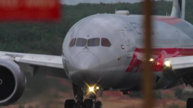 PHUKET, THAILAND - 26 HAZİRAN 2023: Etihad Airways 'in Dreamliner Boeing 787' si ile Phuket havaalanında Formula 1 Abu Dabi 2023 taksicilik yapıyor. Çitin arkasından bak.