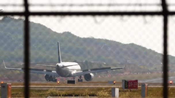 Samolot Pasażerski Ląduje Hamowanie Lotnisku Phuket Widok Samolot Płotem Spoilery — Wideo stockowe