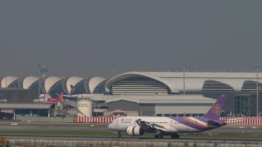 BANGKOK, THAILAND - 01 Mart 2023: Boeing 787 Dreamliner, THAI Airways 'den HS-TQA Suvarnabhumi Havaalanı' na indikten sonra fren yapıyor. Uçak geliyor. Spoiler hazır..