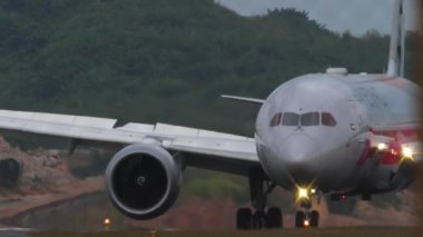 PHUKET, THAILAND - 26 HAZİRAN 2023: Boeing 787 Dreamliner Etihad ve Formula 1 üniforması Phuket havaalanına indikten sonra fren yapıyor.