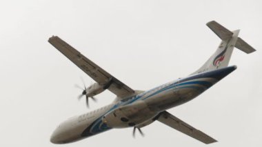 PHUKET, THAILAND - 29 HAZİRAN 2023: Bangkok Air 'in Turboprop uçağı Phuket havaalanında havalanıyor ve tırmanıyor. Yolcu uçuşu, yan görüş. Seyahat kavramı