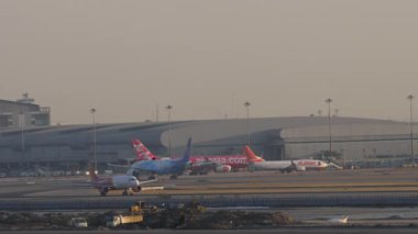 BANGKOK, THAILAND - 19 HAZİRAN 2023: Airbus A320, Tayland Jet HS-VKS Suvarnabhumi Havaalanı 'ndan havalanır. Uçak kalkıyor. Arka planda uçak var. Uçak kalkıyor. Seyahat kavramı