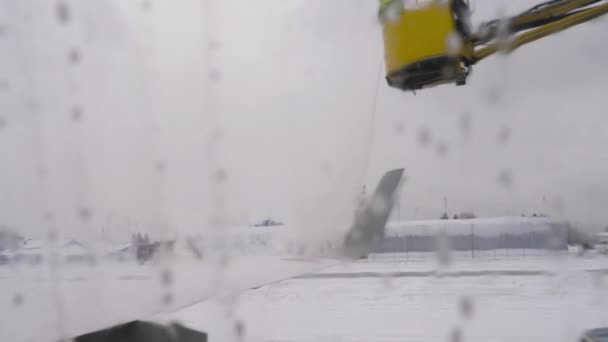 飛行機のデッキ 航空機の氷と雪を取り除くために圧力下に噴霧された化学物質の液体混合物を除去する — ストック動画