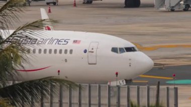 PHUKET, THAILAND - 25 Şubat 2023: Phuket havaalanında taksicilik yapan Malezya Havayolları 'ndan Boeing 737, 9M-MLT. Havaalanındaki uçak. Pistteki uçak görüntüsü, yan görüş. Seyahat kavramı