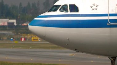 MOSCOW, Rusya Federasyonu - 29 Temmuz 2021 Airbus A330, B-5947 Air China Sheremetyevo havaalanında taksicilik yapıyor. Tıbbi maskeli pilot, pandemik dönem, koronavirüs.