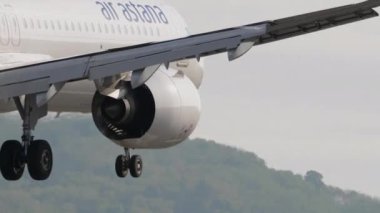 PHUKET, THAILAND - 19 Şubat 2023: Phuket havaalanına inen Air Astana 'nın modern yolcu uçağı Airbus A321. Uçak mavi denizin üzerinde uçar. Seyahat kavramı