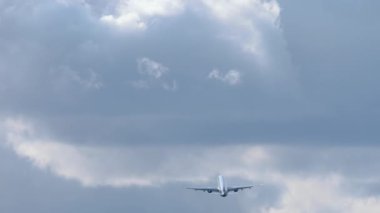 Gökyüzünde irtifa kazanan bir jet uçağının arka görüntüsü. Yolcu uçağı kalkıyor. Kalkış uçuşu