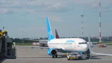 SAINT PETERSBURG, RUSSIA - 26 Temmuz 2022: Bir traktör, Pobeda 737 sefer sayılı jet yolcu uçağını Pulkovo, St. Petersburg havaalanındaki piste çekti.