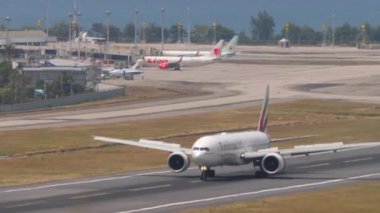 PHUKET, THAILAND - 13 Şubat 2023: Phuket havaalanına indikten sonra fren yapan Boeing 777 Emirates uçağı. Jet uçağı yolcu uçağı geliyor. Turizm ve seyahat kavramı