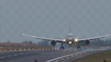 Geniş gövdeli uçak Phuket Havaalanı pistine iniyor ve ona dokunuyor. Çitin arkasından bak. Havaalanındaki uçak. Seyahat kavramı