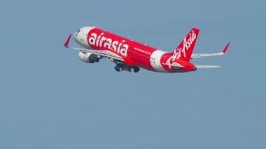 PHUKET, THAILAND - 3 Aralık 2018 Airbus A320, AirAsia 'dan HS-BBI, Phuket havaalanında kalkış ve tırmanış, yan görüş. Gökyüzünde bir uçak. Yolcu uçağı kalkıyor