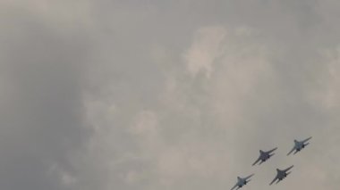 Askeri uçaklar akrobatik manevralar yapıyor. Uçak ordusu. Havada dönen uçak, aşırı uçuş.