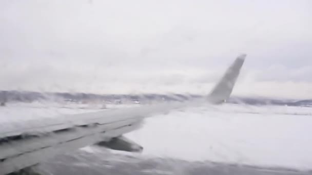 飛行機は冬の日に離陸するためにスピードアップします ポートホールは アンチエイジング混合物で覆われています — ストック動画