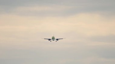 Jet uçağı inişe geçiyor. Uçak iniyor. Yavaş çekim, uçak uçuşu, ön manzara.